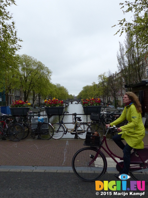 FZ014559 Push biker on Amsterdam canal bridge